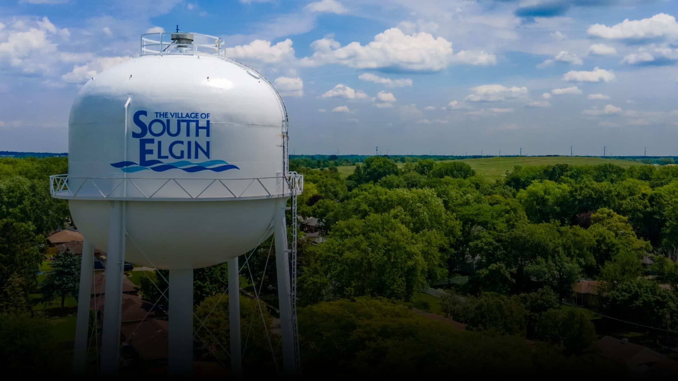 Water tower in South Elgin, Illinois, surrounded by lush greenery and trees